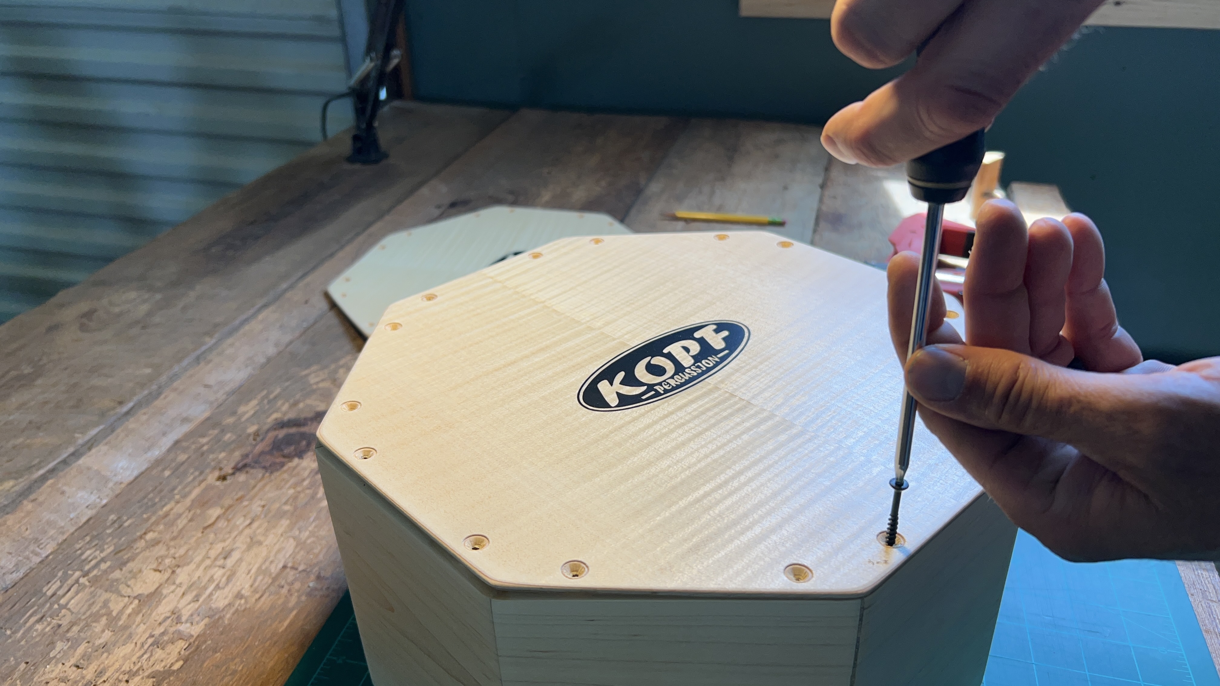 Close-up of Stephen Head using hand tools to shape a cajón component in his one-man percussion workshop.