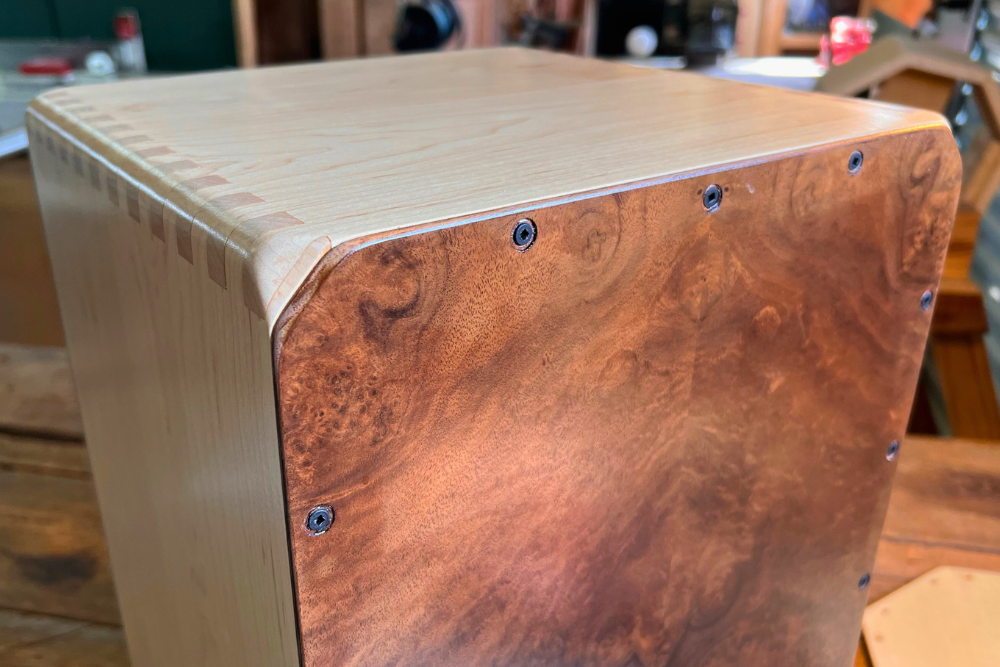 A detailed look at a finished maple cajón faceplate, highlighting the natural figure of the wood and careful joinery.