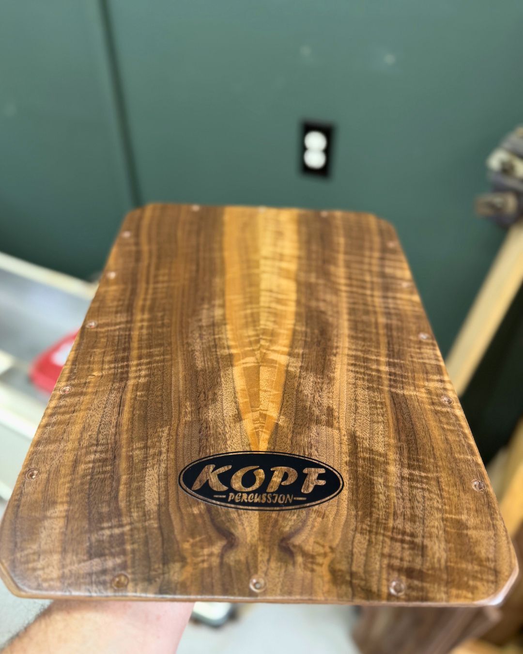 Bookmatched fiddleback walnut cajon faceplate showing mirrored grain figure after lacquer finish