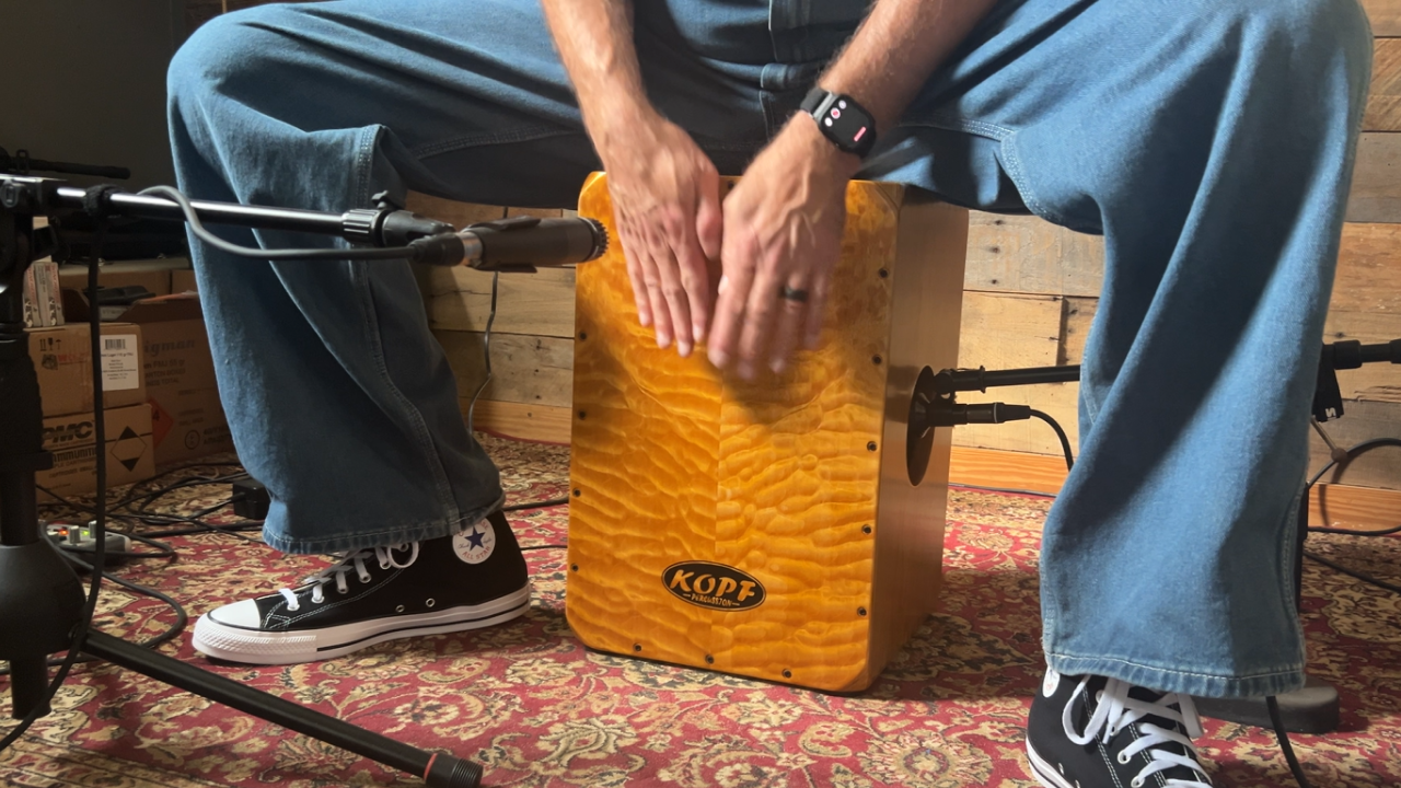 A finished handcrafted cajon by Kopf Percussion resting on the workbench, representing the balance of craft, intention, and the life built through percussion making.