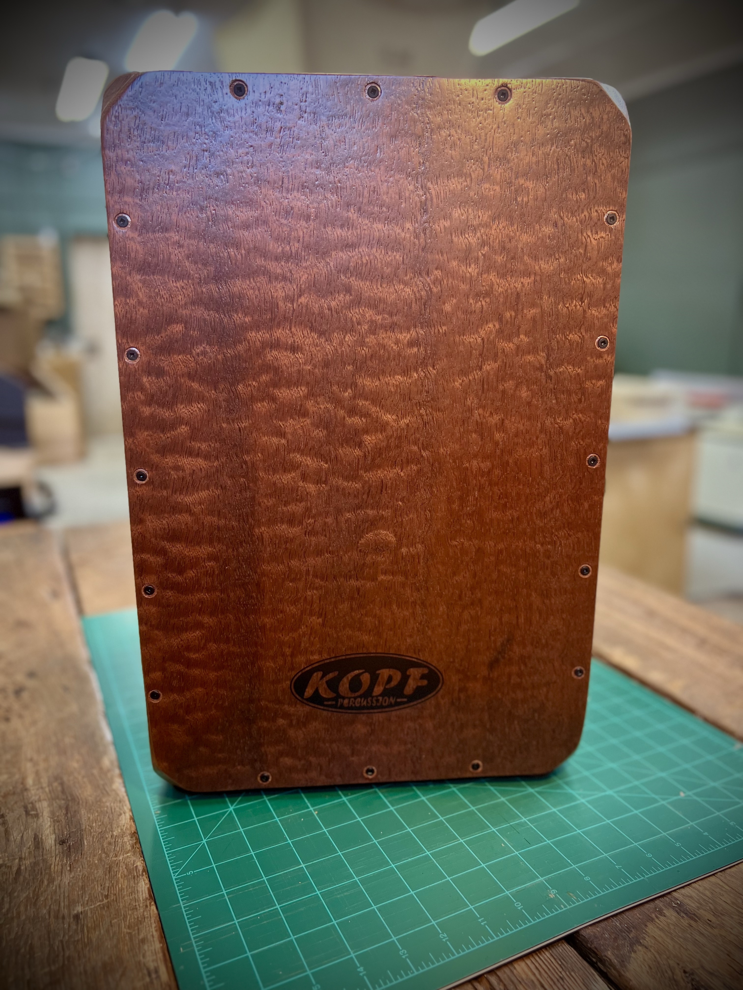 3. Finished Cajon Image (After paragraph about the completed instrument)  File name: finished-pomelle-sapele-cajon-kopf-percussion.jpg  Description: A finished Pomelle Sapele cajon, photographed in natural light at a front three-quarter angle.