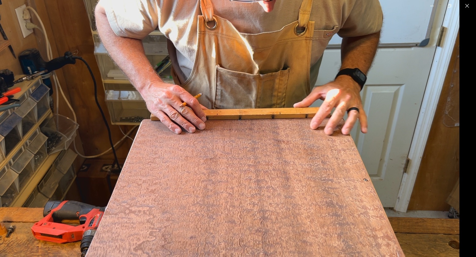 Wide studio shot showing the finished Pomelle Sapele cajon among other handcrafted percussion instruments and tonewoods.
