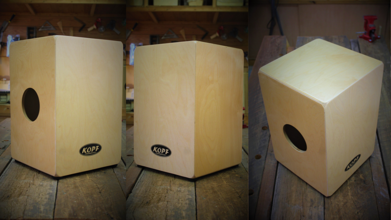  The Novato Cajón sitting on the workbench at Kopf Percussion. This handcrafted cajón is built from Baltic Birch and features dual playing surfaces with a side sound hole.