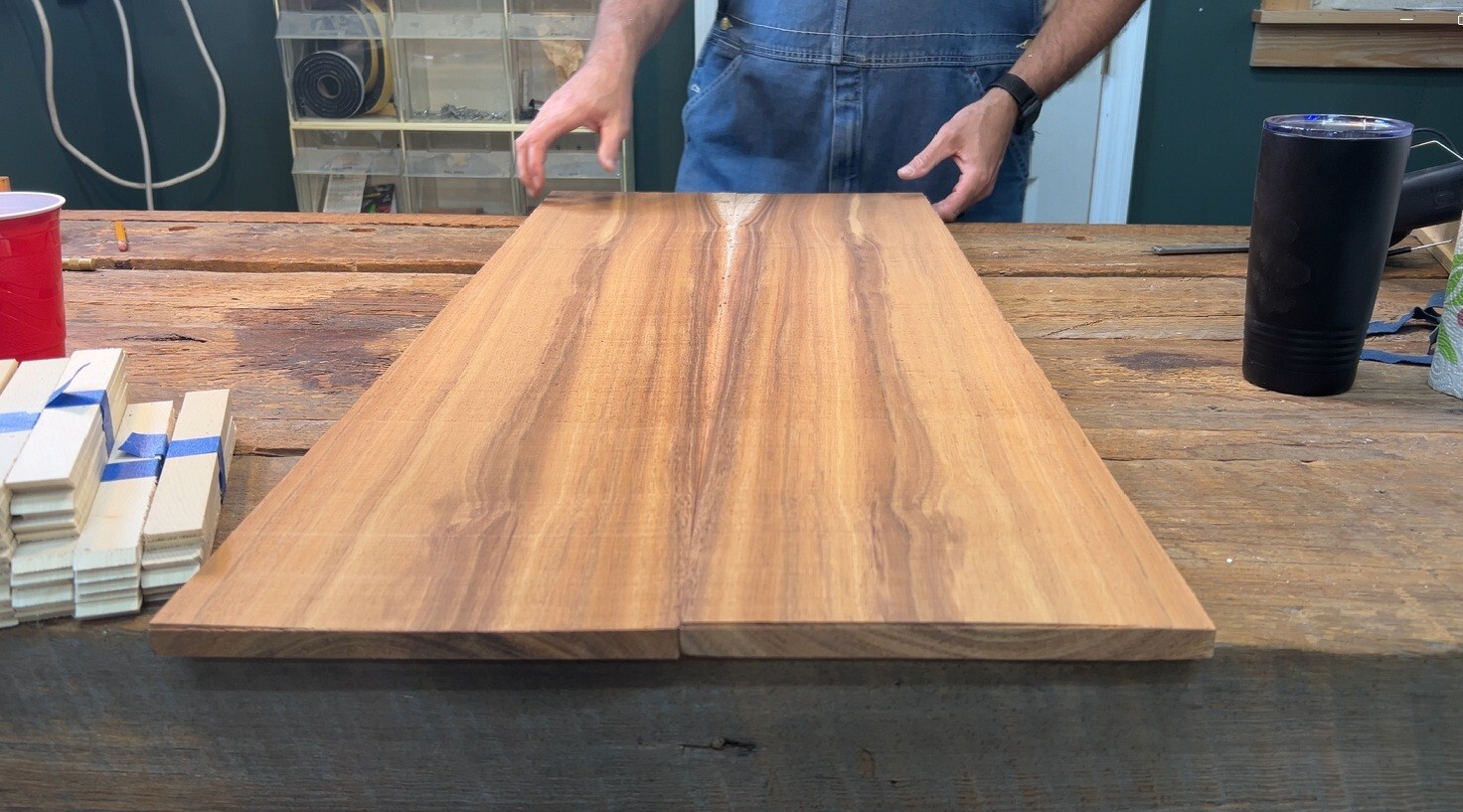 Studio photo showing bookmatched solid koa panels laid out on the workbench at Kopf Percussion. The panels display the natural symmetry, color, and figure of koa before final assembly. This image represents the patience, respect, and craftsmanship that define Stephen Head’s approach to building instruments from rare tonewoods.