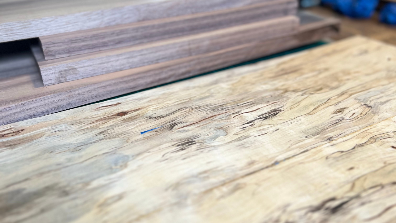 Close-up of walnut and maple wood grain used in Kopf Percussion cajon building, showing the natural character and story carried in every handcrafted instrument.