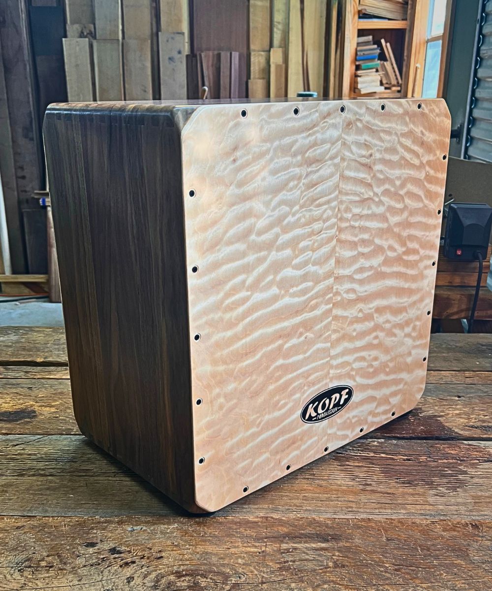 Handcrafted Walnut Cajon with quilted maple tapas, delivering deep bass and crisp slap tones.